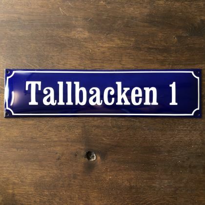 Husskylt i emalj, max 14 tecken. Svart skylt med vit text.