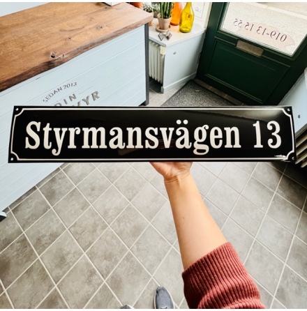 Husskylt i emalj, max 18 tecken, svart bakgrund med vit text