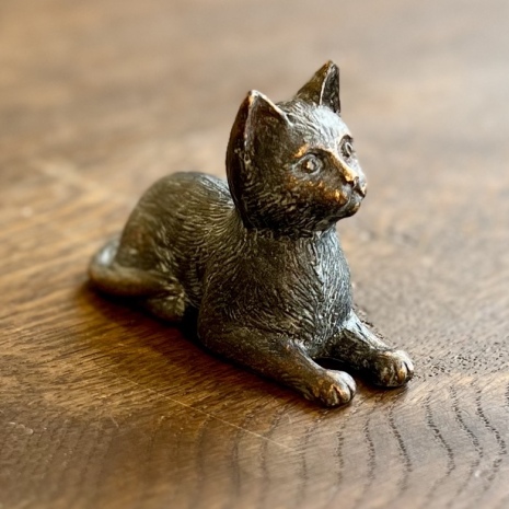 Liggande katt i gjuten brons