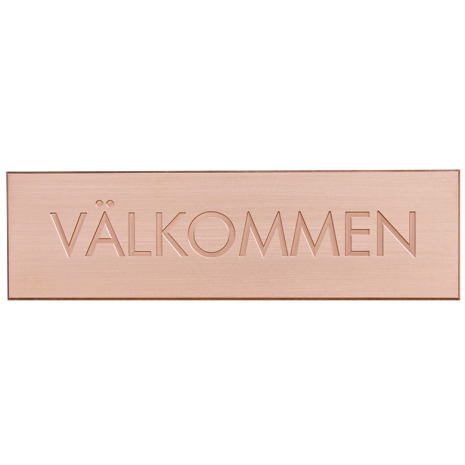 Vlkommen skylt med texten vlkommen graverad i stora bokstver